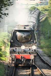 乘客怀旧力量古老的蒸汽机车经过一个交叉点图片