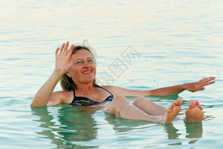 女人躺在死海的水面上绿色死重图片