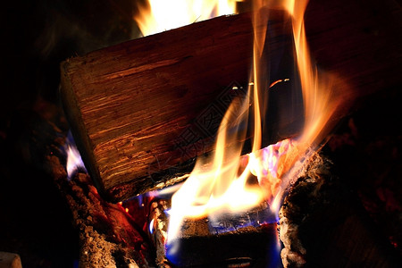 明亮的篝火发光在壁炉中燃烧火焰和木柴图片