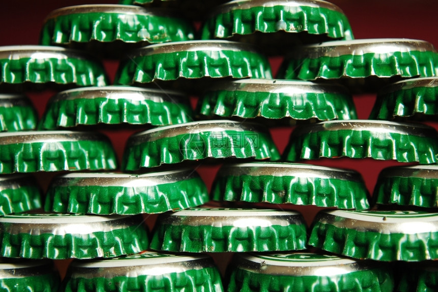 盖帽绿色啤酒堆积的绿色啤酒盖为背景而关闭好圆形的生气了图片