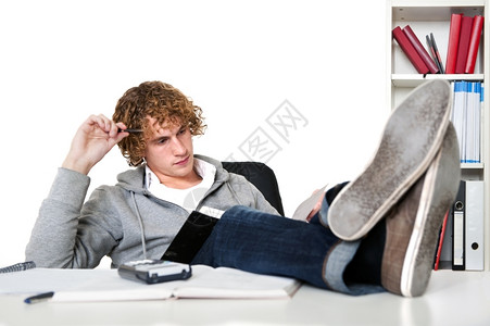 自在书架男人年轻子在书桌上用脚学习图片