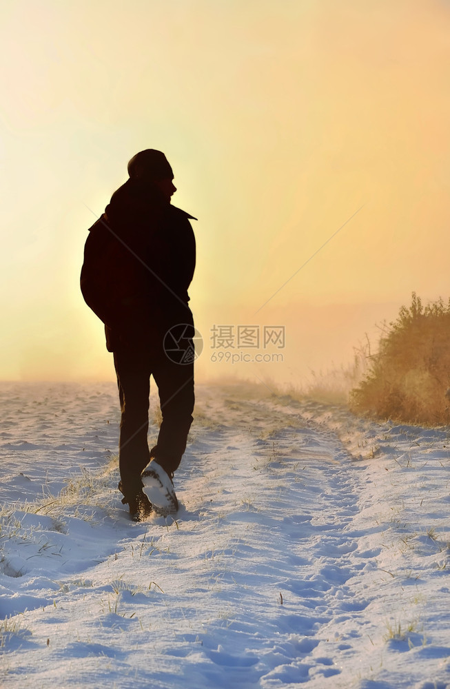 雪步行冬天日落时在农村道路上行走的男子月光图片