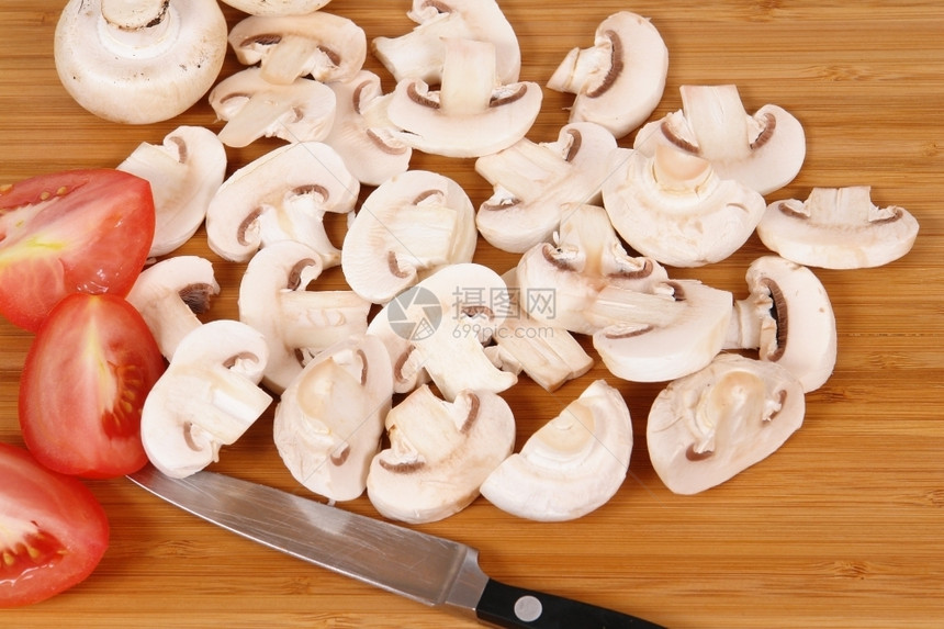 在棕色砧板上切蘑菇白色的生切割图片
