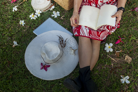 坐在草坪上看书的女士图片