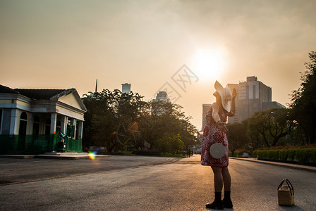 女青年在夏日夕阳的天空下放松图片