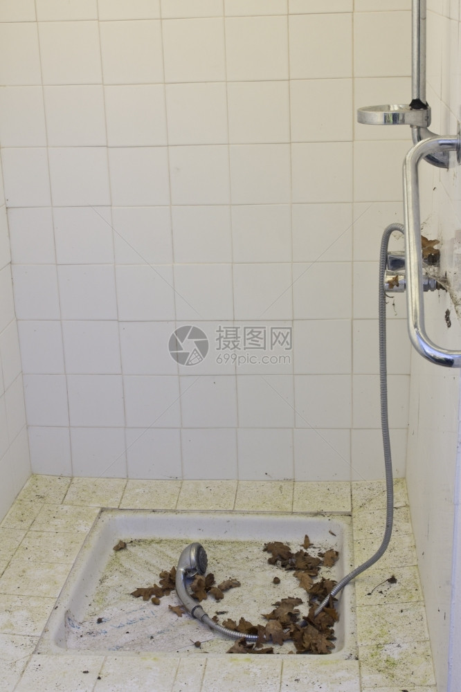 被忽略的肮脏淋浴室有叶子垃圾摇滚洗肮脏的图片
