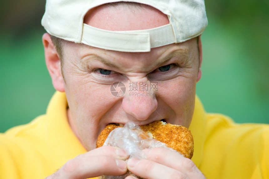 男人看着相机和咬甜圈欧洲的吃男图片