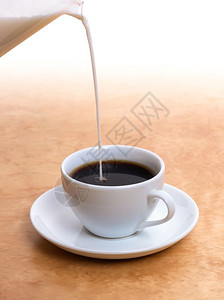 将新鲜牛奶倒入热咖啡中图片