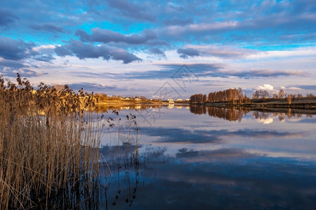 乌沃德河岸在日落的金光下和水中闪耀的美丽云彩环境光线天空图片