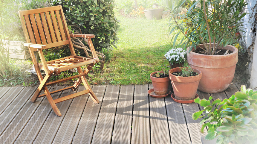 植物露台家夏天在花园的木阳台上坐着椅子图片