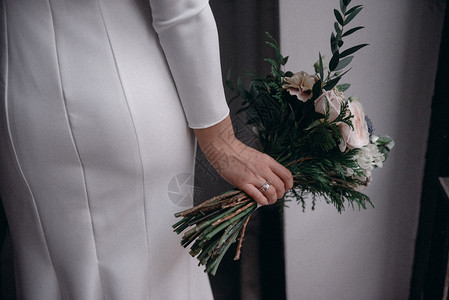 穿着婚纱的新娘手拿婚礼花束背景图片