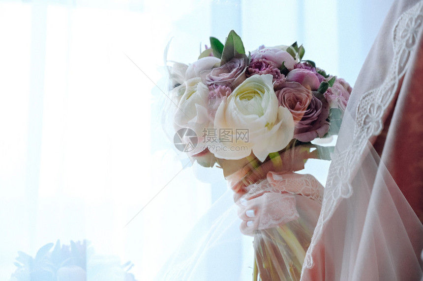 穿着婚纱的新娘手拿花束图片