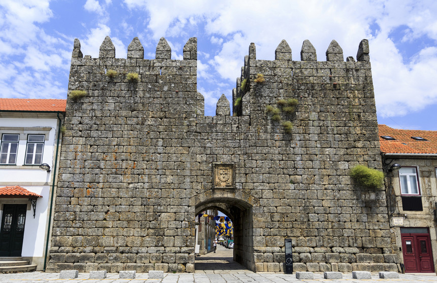 外套居中拱在葡萄牙历史城镇特兰科索位于两座交火的塔楼之间中世纪国王门外的景象图片