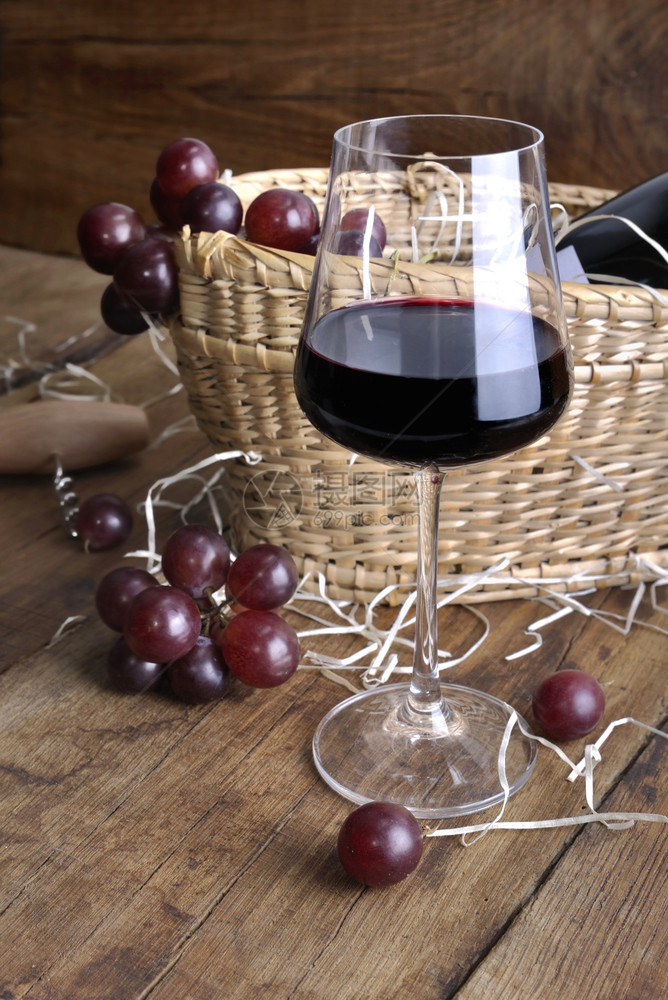 瓶子葡萄篮上前的酒杯以生锈木制背景用瓶装酒供应葡萄精品尝图片