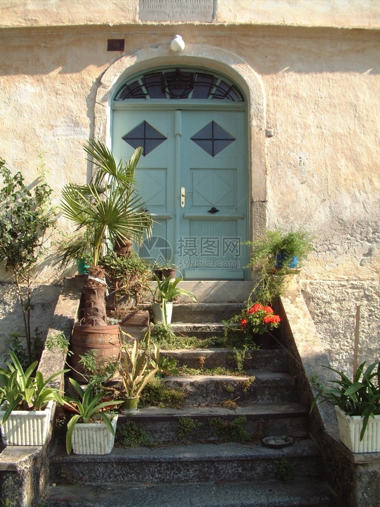 正面建筑的绿色大门和花朵的入口家图片