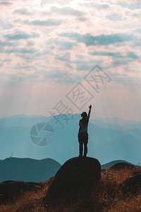 伸手触碰天空的登山者图片