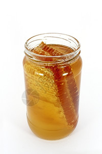 蜜蜂满的玻璃罐装蜂蜜和窝的在白色上隔离黄的图片
