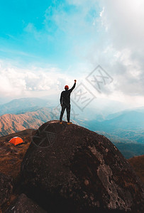 伸手触碰天空的登山者背景图片