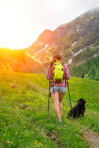 带着狗狗一起登山冒险的年轻人图片