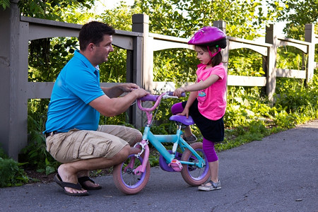 父亲教女儿骑自行车背景图片