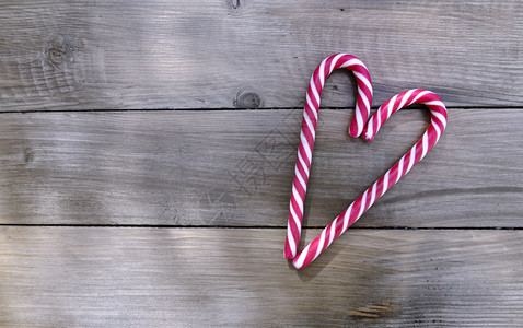 手杖古老的浪漫卡片有糖果甘蔗在木制背景上形成心脏圣诞节木板图片