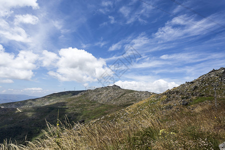 山上的白云蓝天和荒草地背景图片