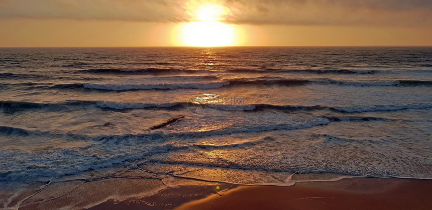 葡萄牙日落时从PraiaValeFigueiras起飞户外水海浪图片