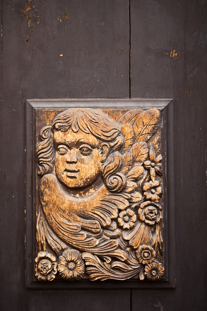 老的街道在捷克布拉格的一扇街门上雕刻天使的旧木拉根图片