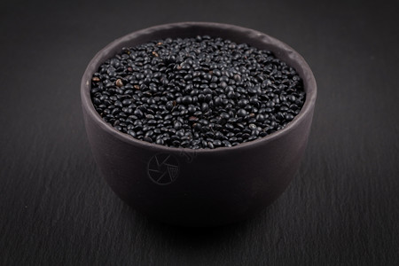 黑暗的在白色孤立小型黑碗杯中有许多黑白鱼扁豆种子营养杯图片
