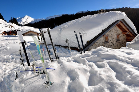 雪山上的小木屋和滑雪用具背景