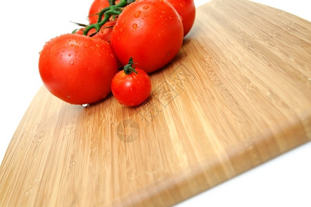 一种红色的蔬菜密闭大小西红柿在木制切割板上放水滴子图片