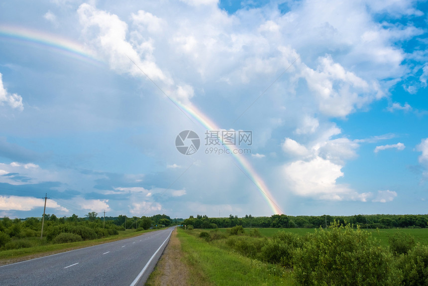 乡村的自然多彩虹对抗乌云天和湿沥青路俄罗斯蓝色的图片