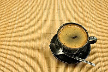 休息早晨咖啡因黑杯带条纹的竹桌布图片