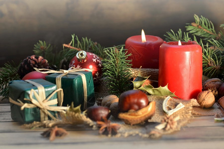 冷杉带有蜡烛和礼品的木背景传统圣诞节装饰并配有蜡烛和礼品火焰装饰图片
