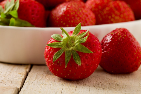 碗水果木制桌子上美味的红草莓照片图片