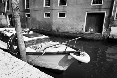 建筑学老的旧船在意大利威尼斯一流运河上停泊在意大利威尼斯沿河建筑上的老船狭窄背景图片