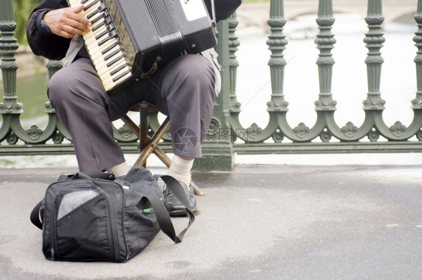 一个街头音乐家在帕里斯柯的一座桥上演奏手风琴一种运动的街道图片