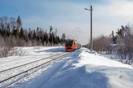 俄罗斯阳光明媚的冬季日白色雪中的红程列车运输一种户外图片