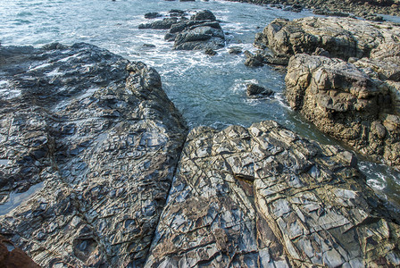 自然生态沿着海岸上被浪撞击的岩礁石群图片