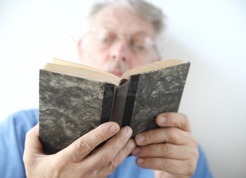 正在翻阅一本老书的老人图片