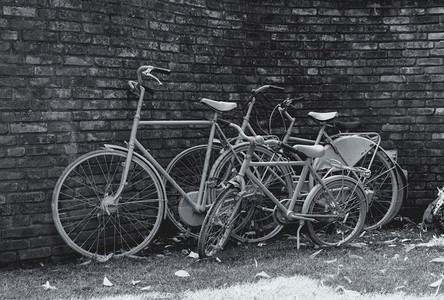 白色的结石用过三辆自行车在黑白的石墙前撒草图片
