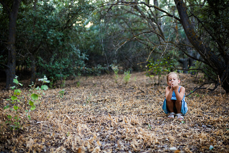 蓝色的寂寞悲伤小女孩沉浸在森林感觉的概念中情怀金发女郎图片