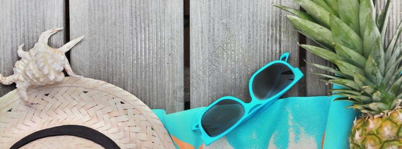 假期夏天草帽海滩毛巾太阳眼镜和木台上菠萝的顶部风景贝壳图片