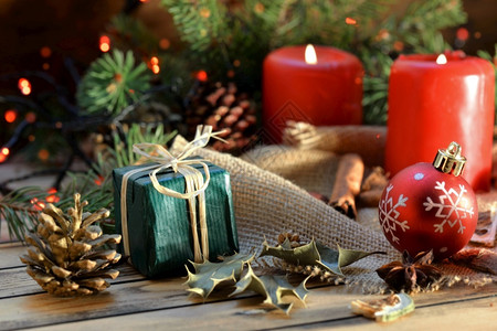 木制背景上的传统圣诞节装饰蜡烛和鲜光明灯的礼物木制季节盒子图片
