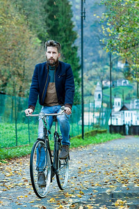 时尚城市在自行车路上骑艇的青年男子轻图片