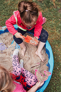 沙盒操场孩童小女在外游乐场玩沙箱戏的夏日真实人情况学前班背景图片