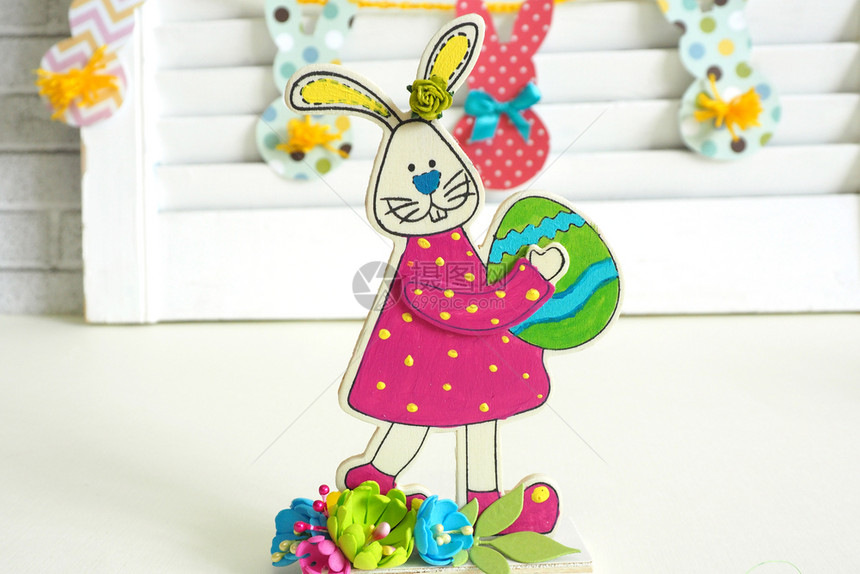 复活节兔子手工涂漆的木制板图家用有彩色纸质兔子和尾巴的复活节日装饰品丰富多彩的屋传统图片
