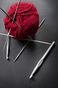 柔软的颜色深背景中的羊毛球和织针纺品图片