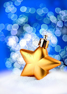 金子色的圣诞装饰明星蓝布基背景金色的闪光效应模糊图片