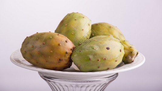 尖的盘子上摆满了四颗美味可口的梨仙人掌水果棘手的绿高清图片